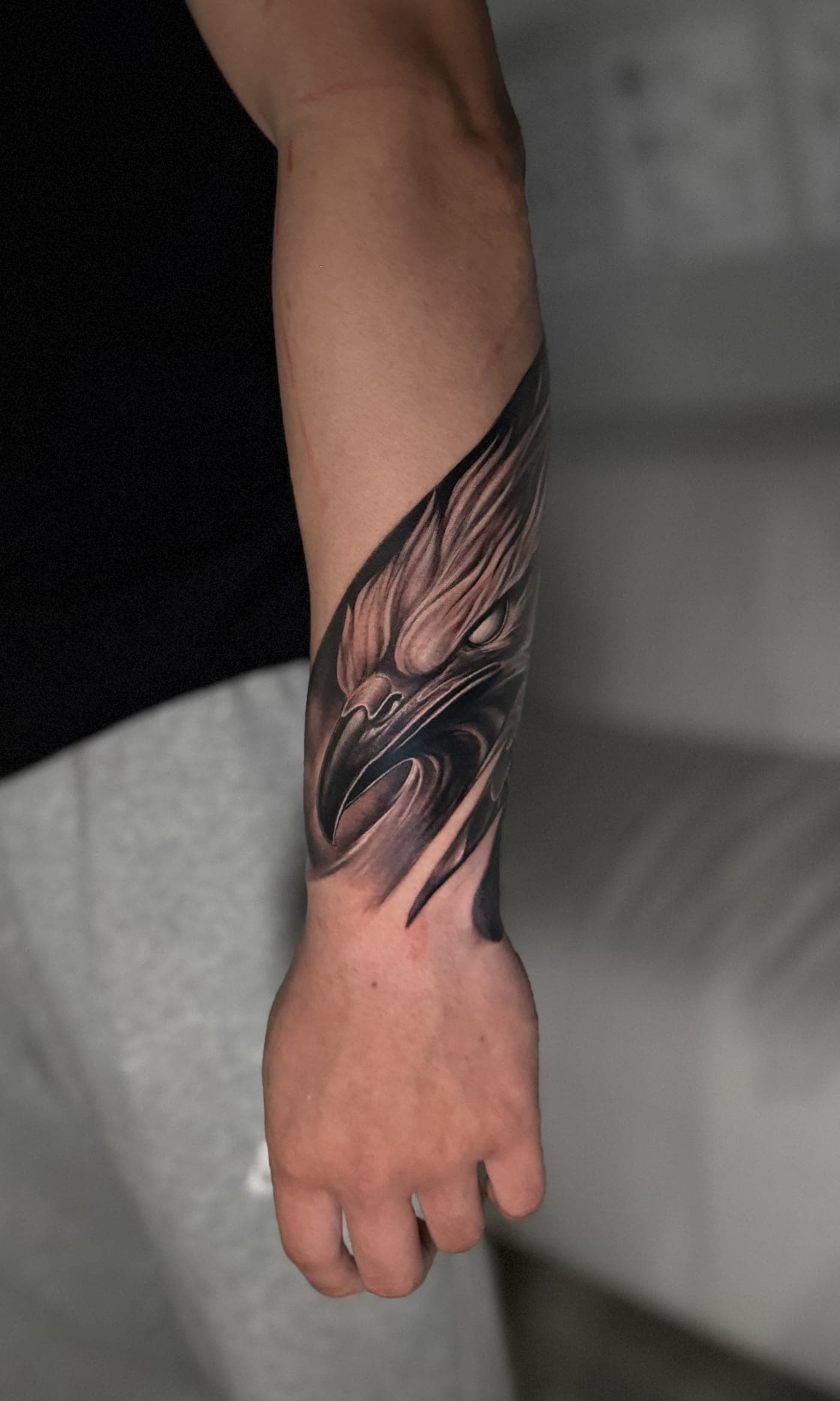 Eagle head forearm tattoo in black and grey